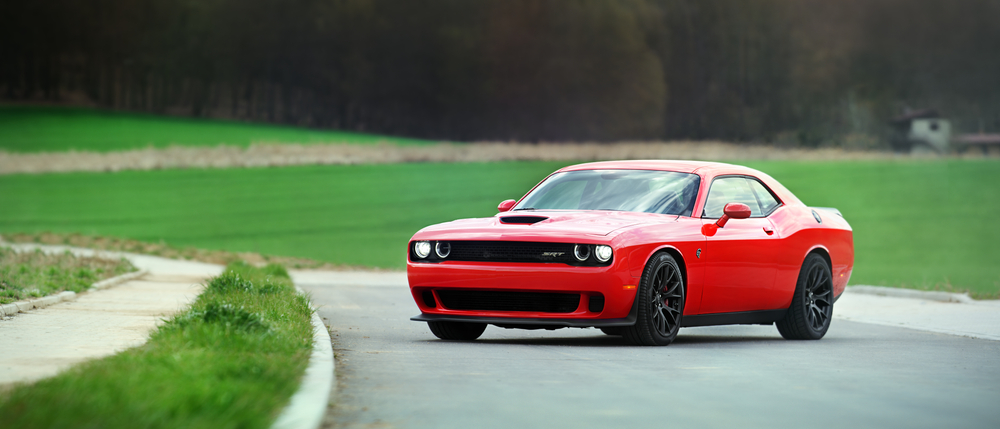 Bright red Dodge Hellcat parked on an open road